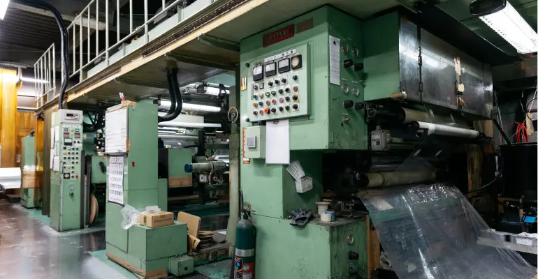 ドライラミネート機でフィルムを貼り合わせ加工する様子