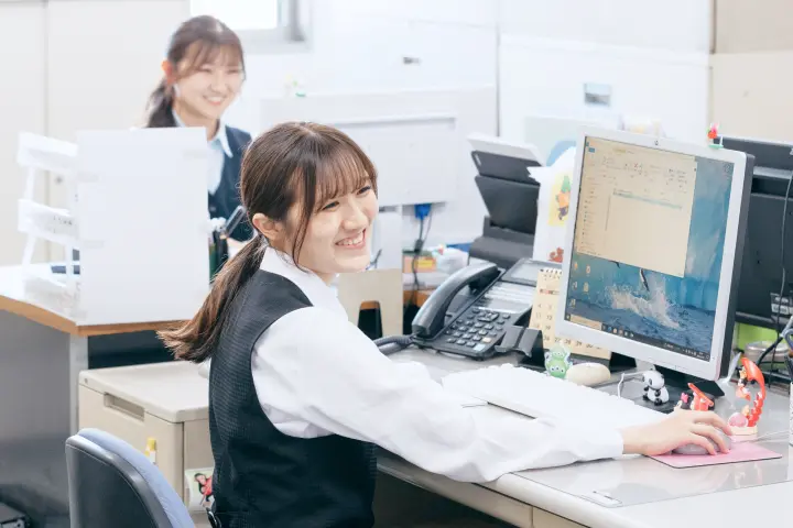 オフィスで笑顔で働く女性社員の様子