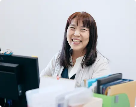 仕事風景デスクで笑顔を見せる事務スタッフ