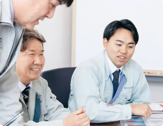 仕事風景打ち合わせ中に笑顔で話す社員たち