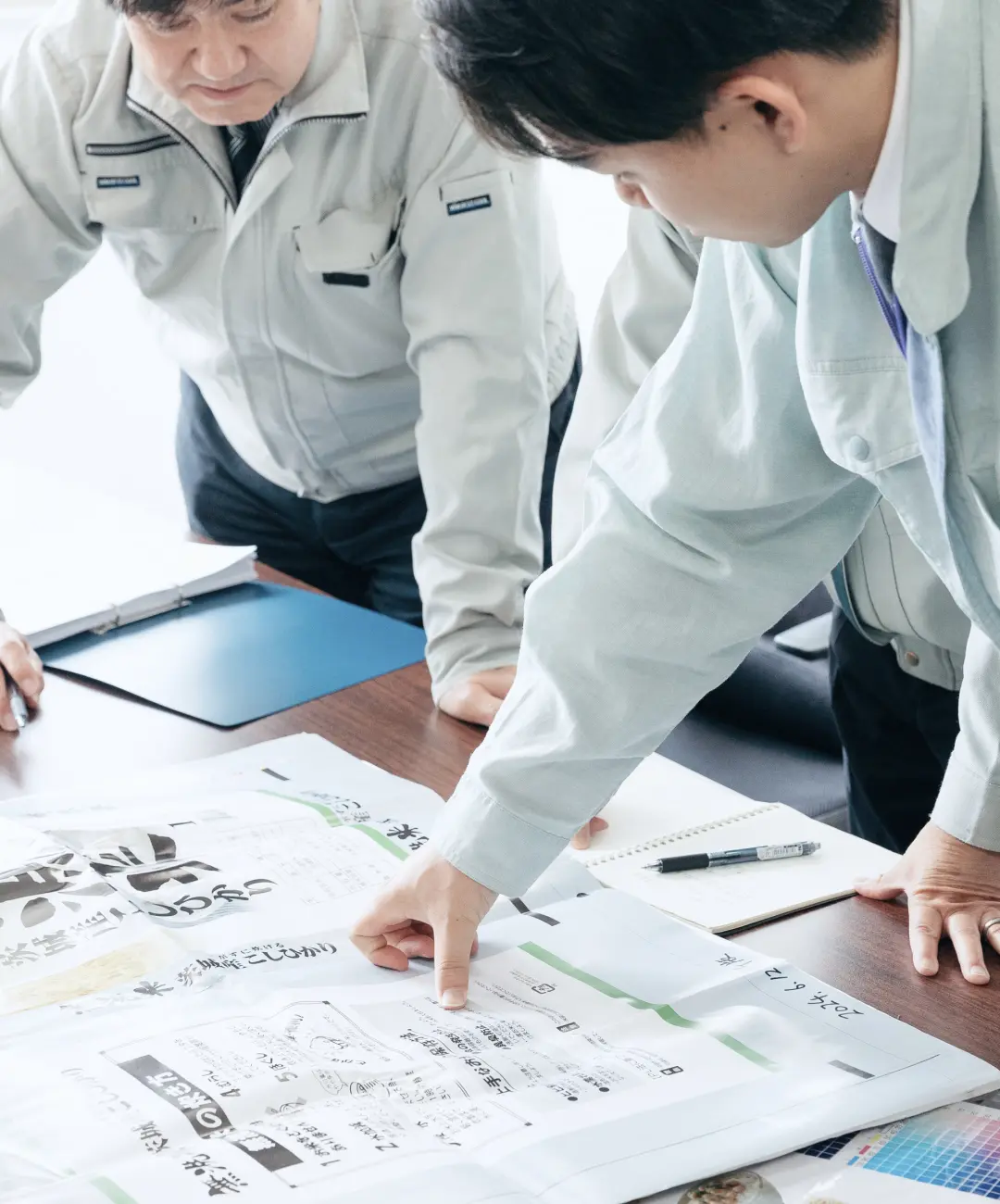 東和グラビヤ印刷株式会社の社員が食品パッケージの印刷見本を確認しながら打ち合わせを行う様子