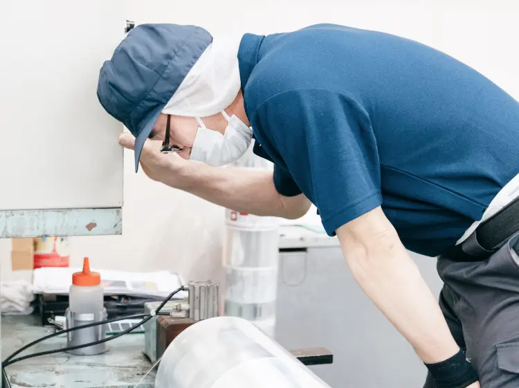 食品パッケージ用グラビア印刷の品質確認を行う作業員